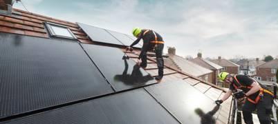 Men installing solar panel on roof