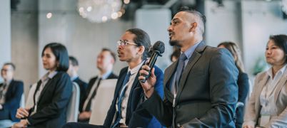 Man in wheelchair speaks into microphone