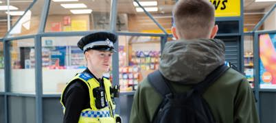 Uniformed police officer speaking to a member of public