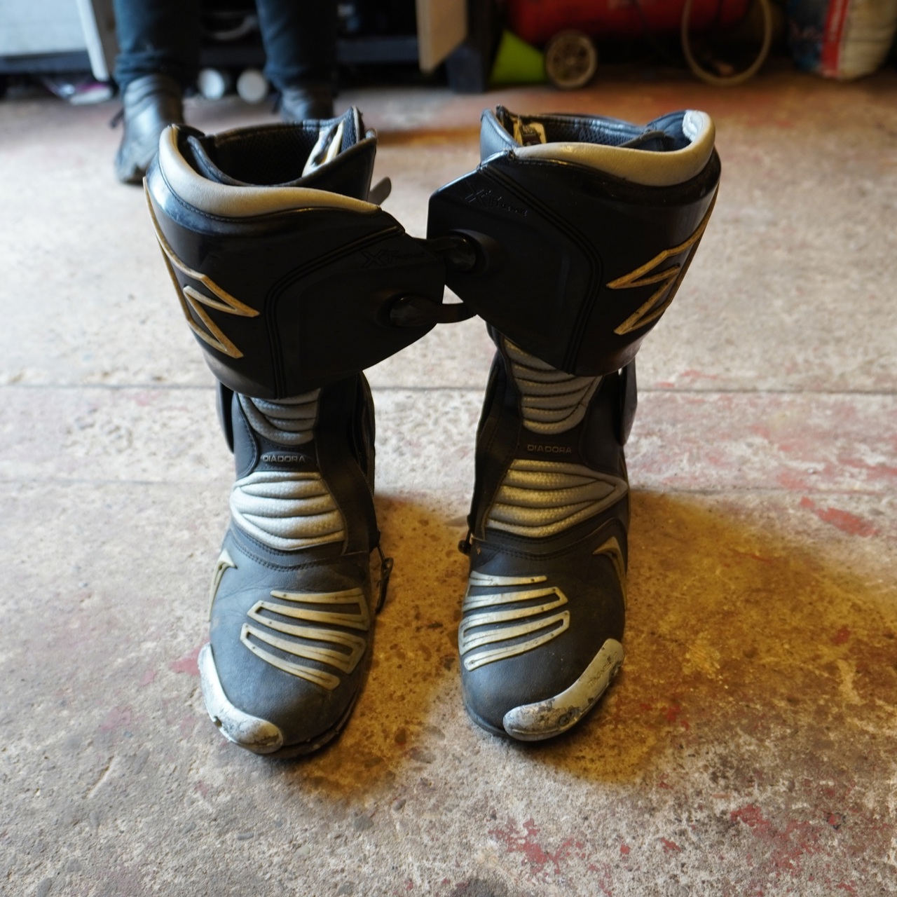 Pair of motorbike boots on the floor of a garage