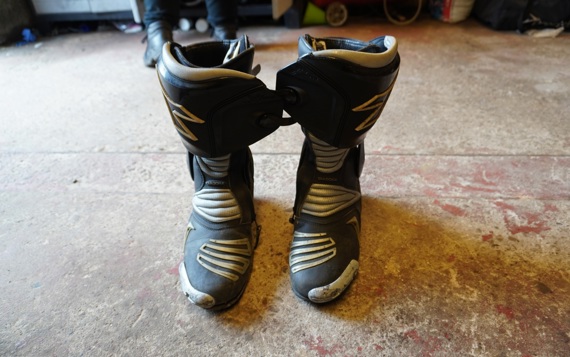 Pair of motorbike boots on the floor of a garage