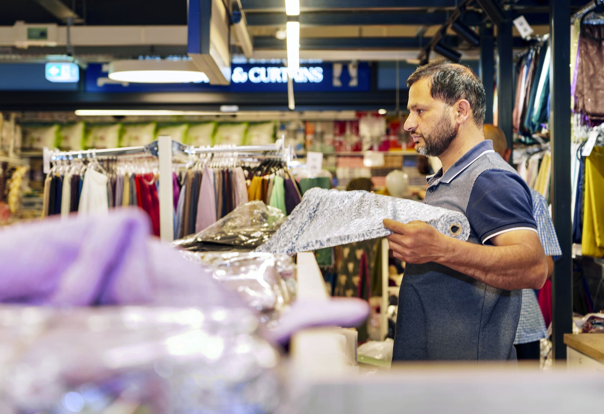 Man measuring out material at fabric shop