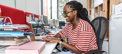 A Black Female Office Worker At Her Laptop