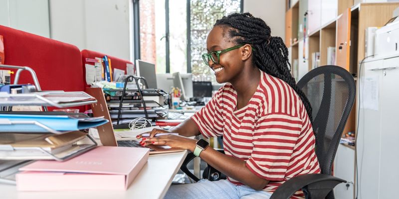 A Black Female Office Worker At Her Laptop Stock