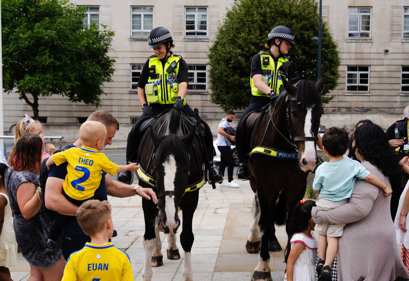 Families watching two police horses
