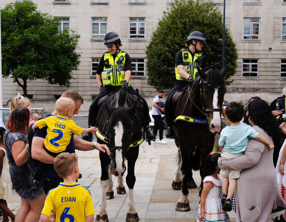 Families watching two police horses