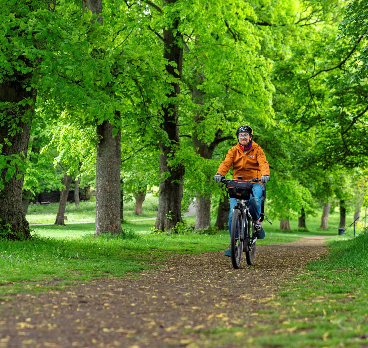 Kit riding his bike on a tree-lined path
