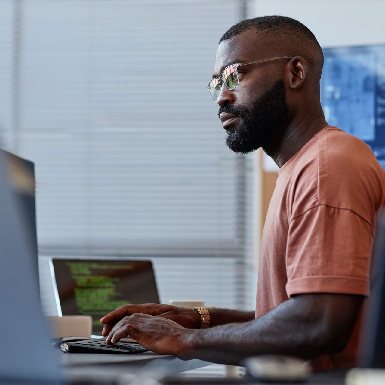 Male software developer sat at computers