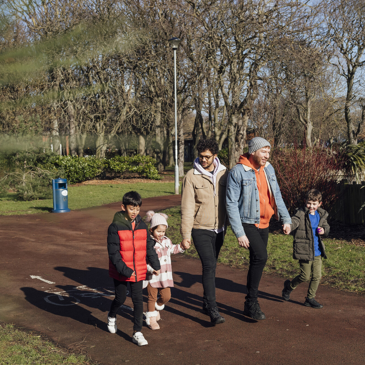 A family of five, walking through a park