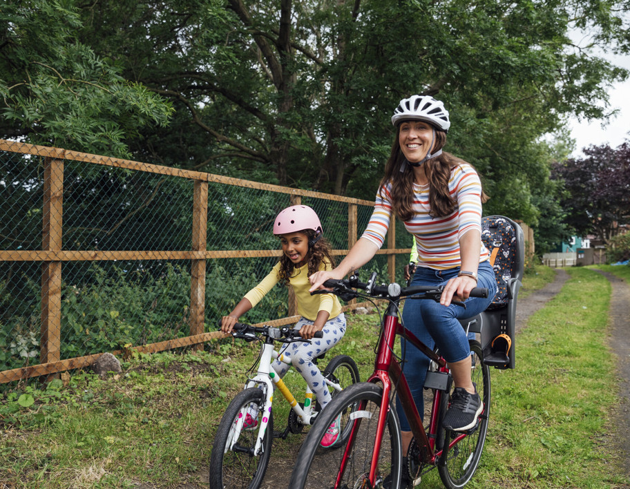 Mother and daughter riding their bikes around a public park