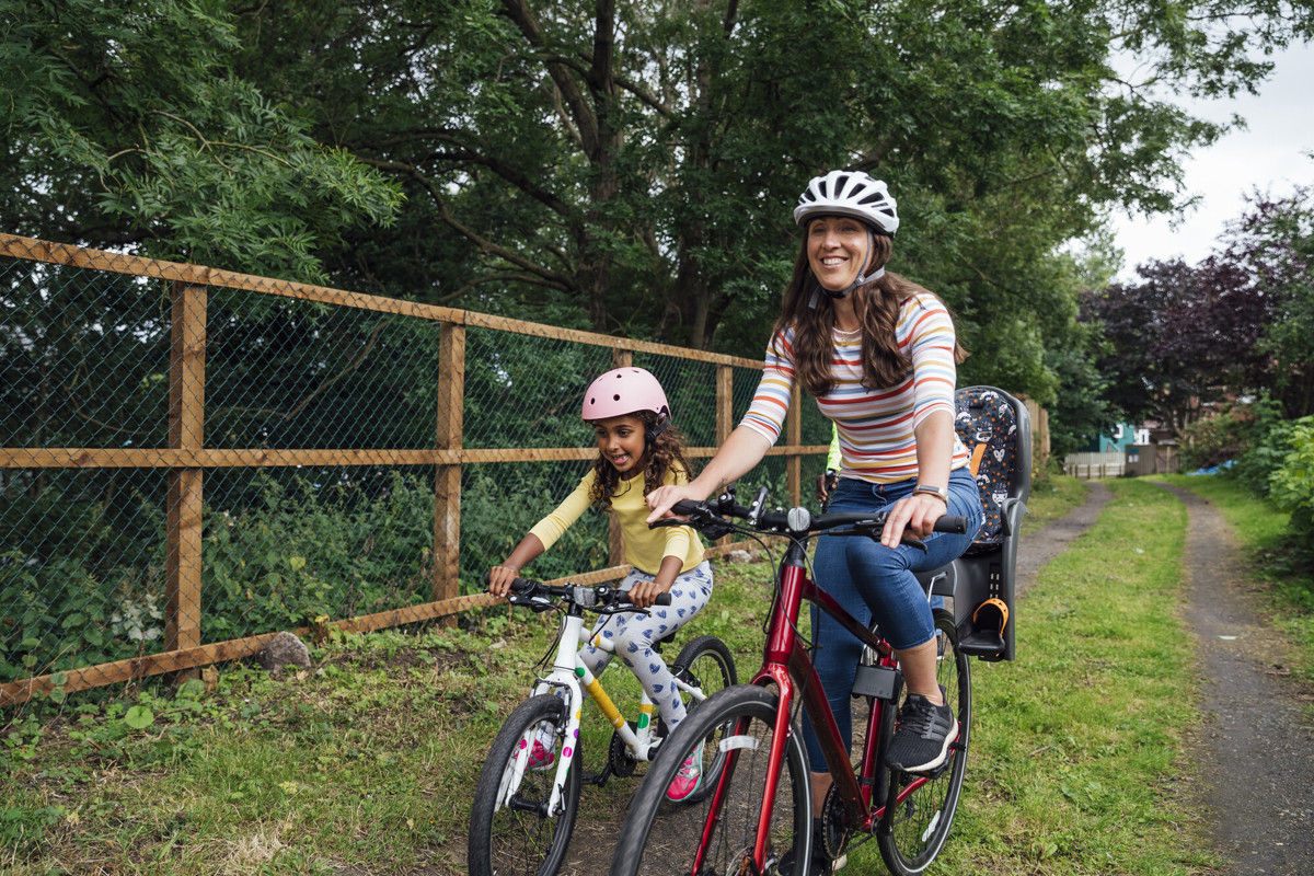 Mother and daughter riding their bikes around a public park