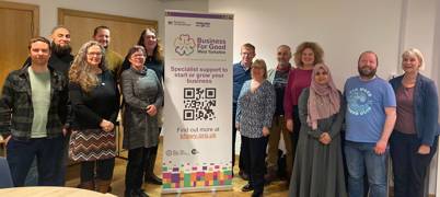 A group of people stood with a Business for Good West Yorkshire sign