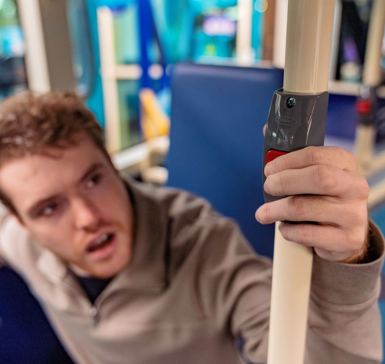 Nathan pressing the stop bell on a bus