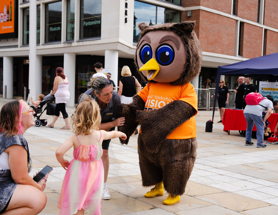 A family greeting an owl mascot for Vision Zero
