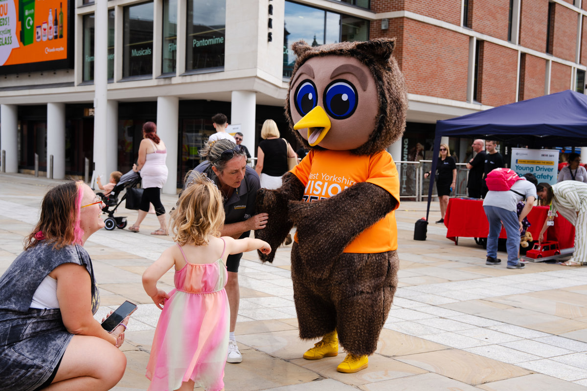 A family greeting an owl mascot for Vision Zero
