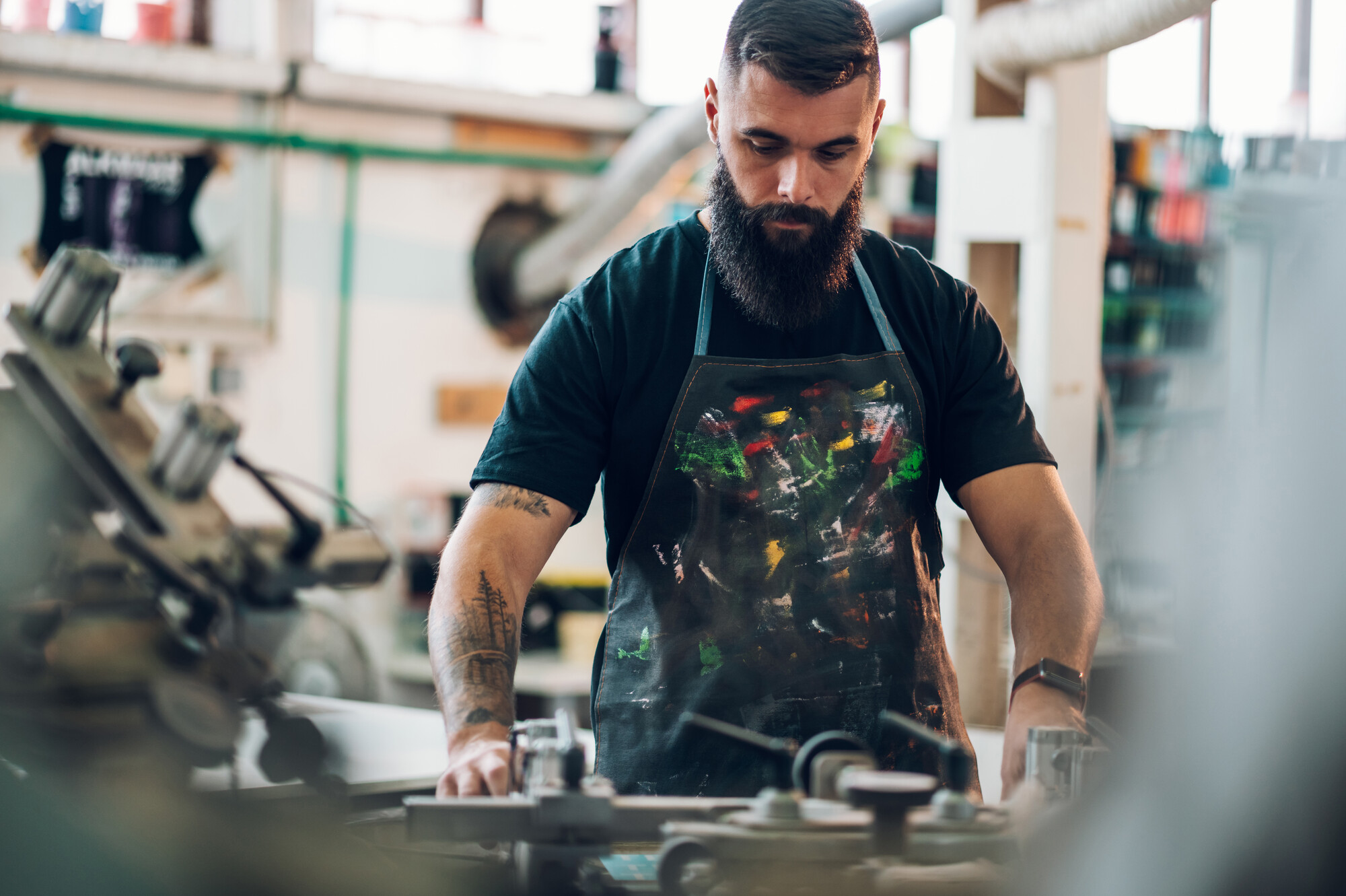 Male Worker Using Screen Printing Film And A Printing Machine In A Workshop