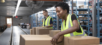 Two people working with boxes on an assembly line