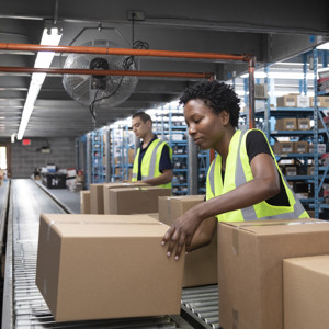 Two people working with boxes on an assembly line