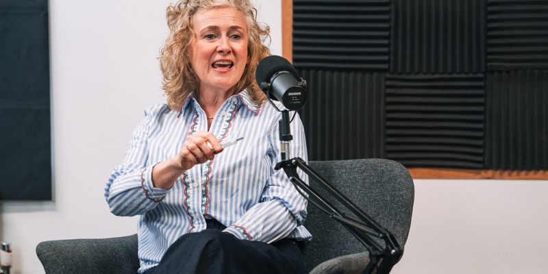Woman sat in a chair, speaking into a microphone