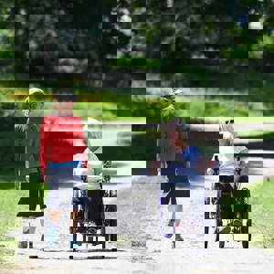 Two People Walking And Wheeling In Park