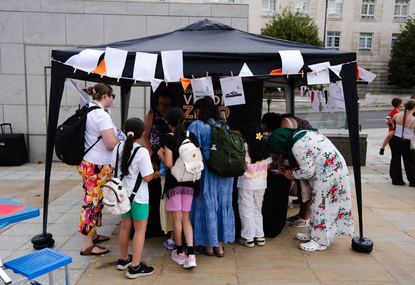 A group of people gathered around an event stall