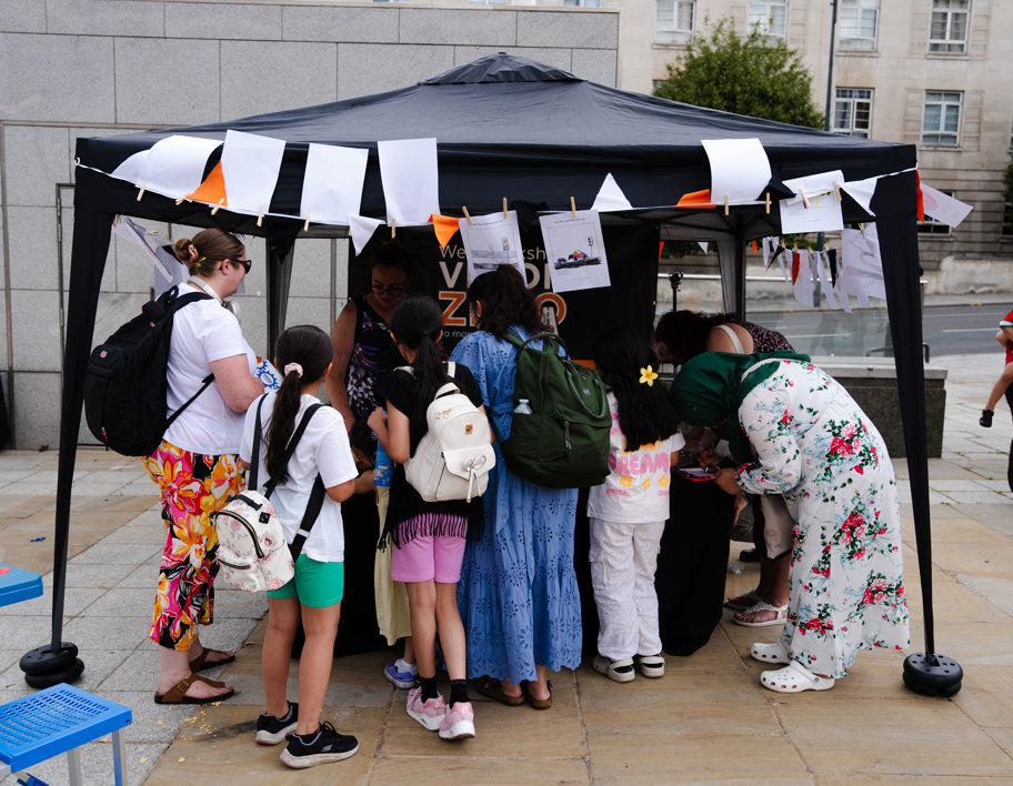 A group of people gathered around an event stall