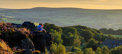 Man and woman on moorland at sunset