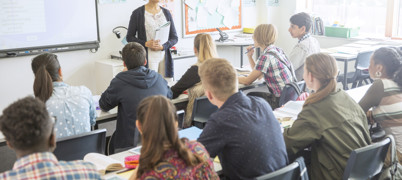 Teacher stands in front of a classroom of students