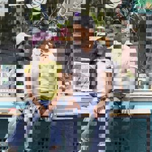 Girl and man sitting on bench outside shop in Saltaire