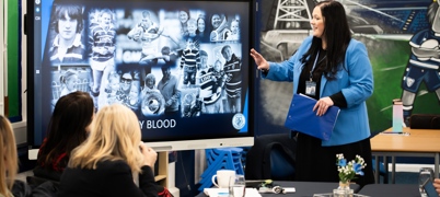 Educator points at screen to adult learners