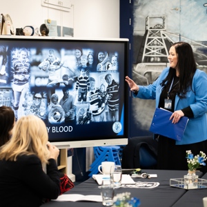 Educator points at screen to adult learners