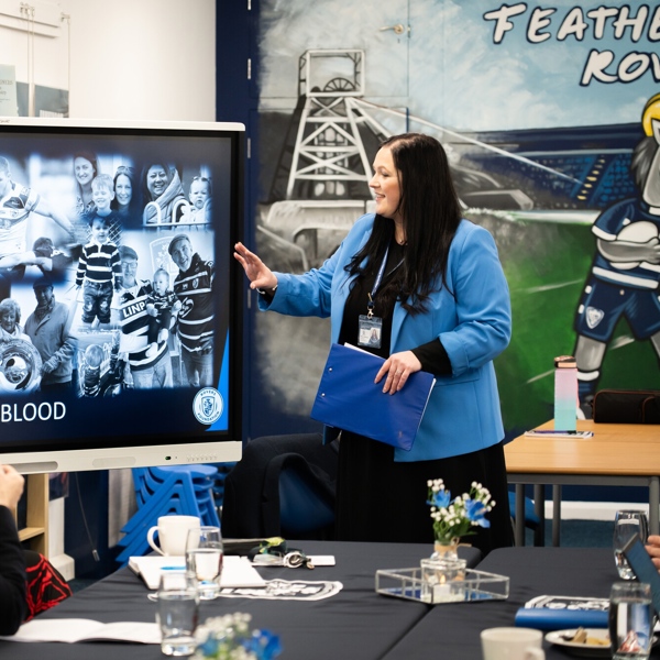 Educator points at screen to adult learners