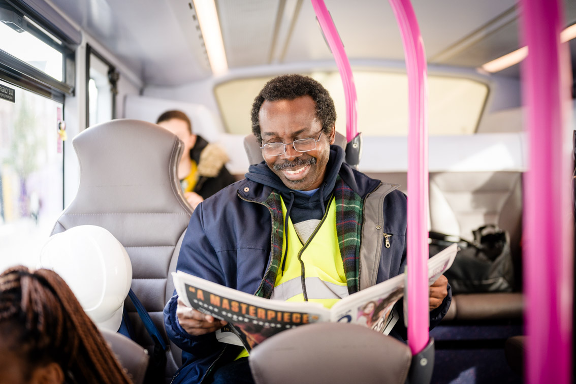 Man on bus reading newspaper