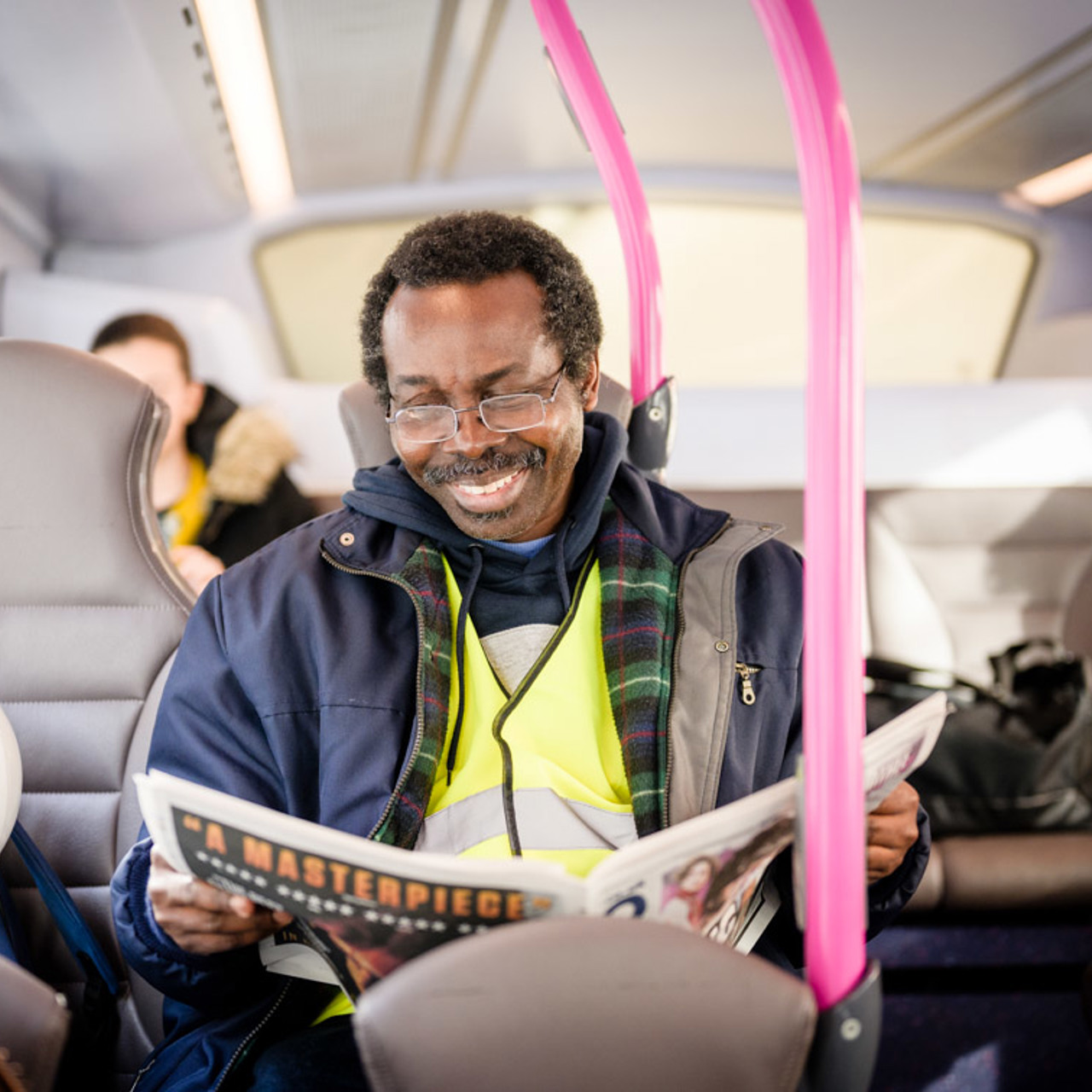 Man on bus reading newspaper