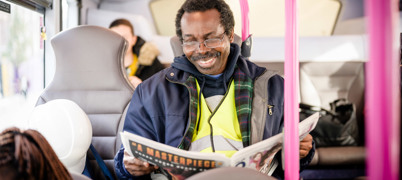 Man on bus reading newspaper