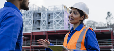 Two people on a construction site having a conversation