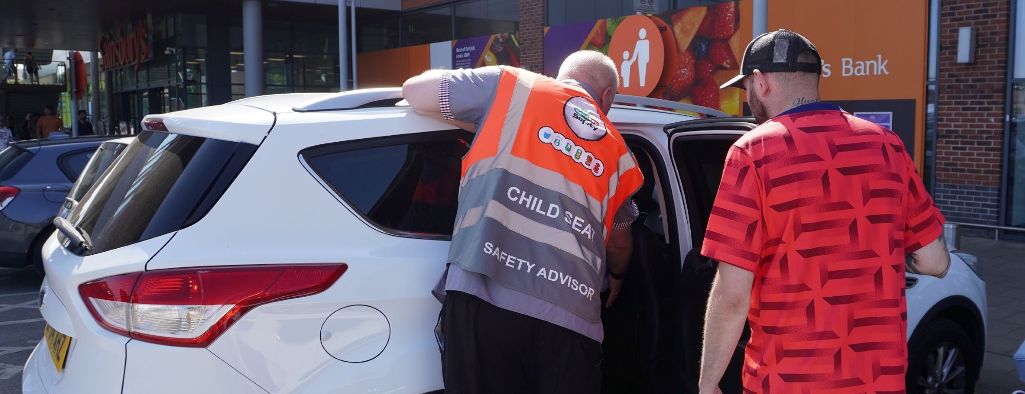 Man checking a child car seat is installed safely