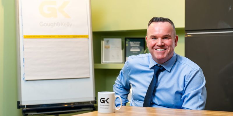 A man sat at a meeting table, smiling