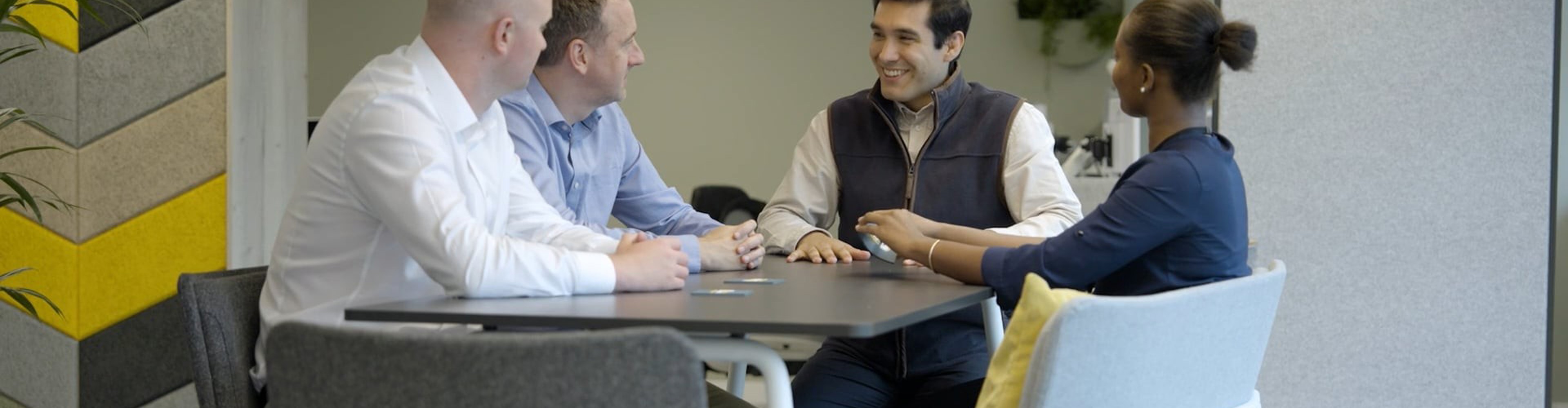 Four people sat around a table for a meeting