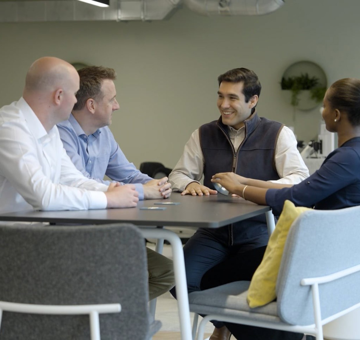 Four people sat around a table for a meeting