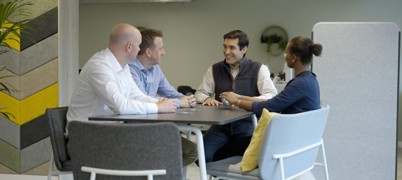 Four people sat around a table for a meeting