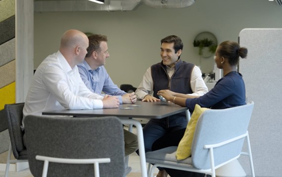 Four people sat around a table for a meeting