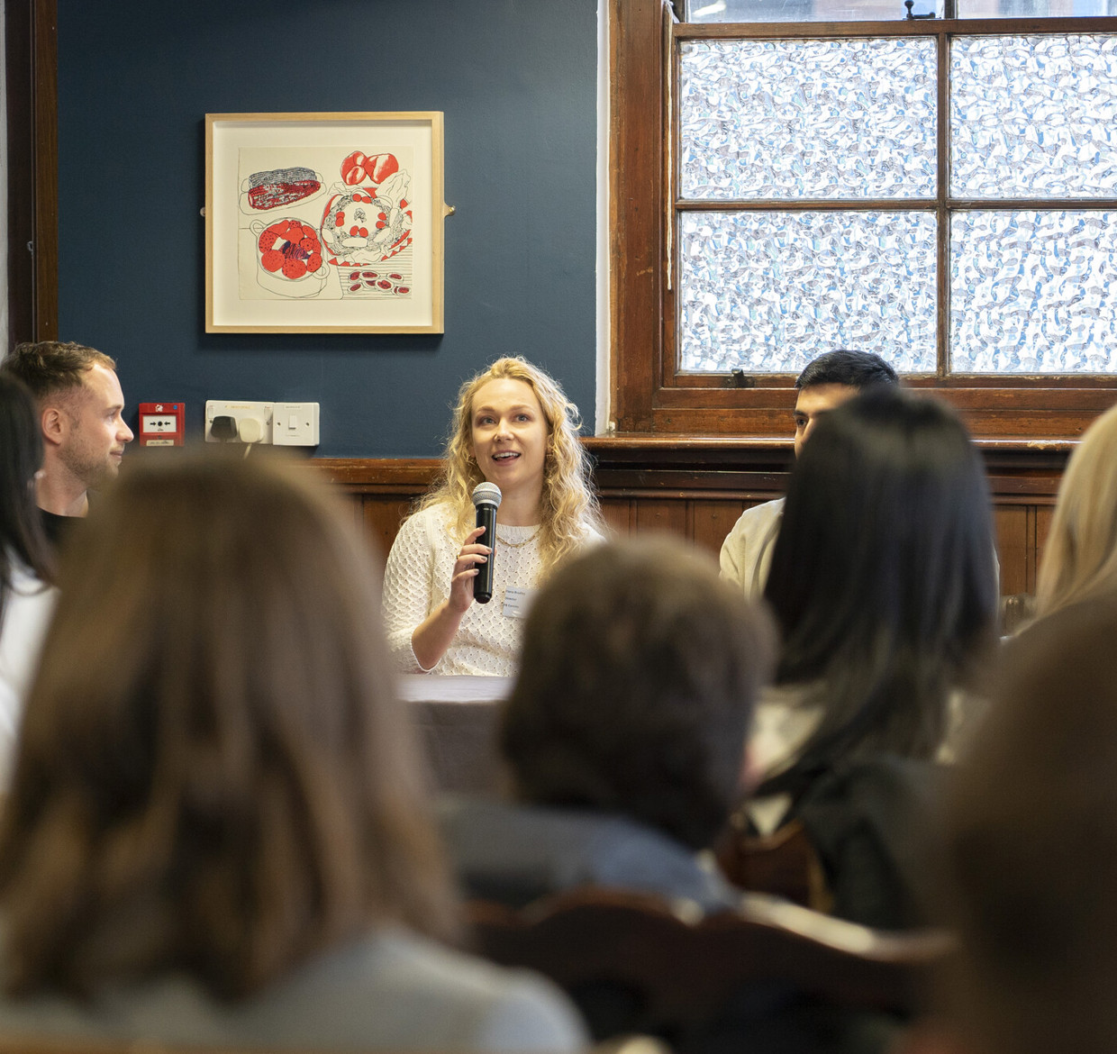 Speaker at graduate event as people listen