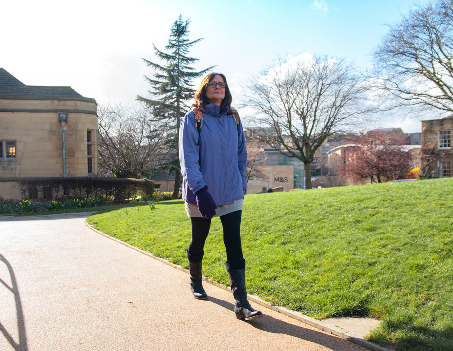 Woman walking along a park path in Bradford