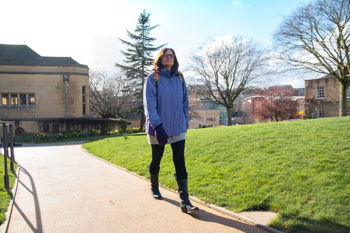 Woman walking along a park path in Bradford