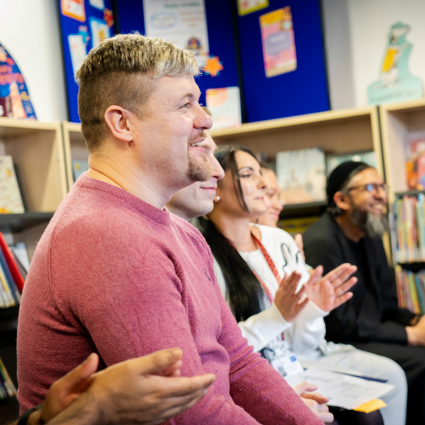 Adult learners sit and smile together at library