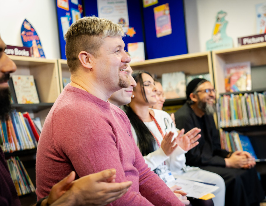 Adult learners sit and smile together at library