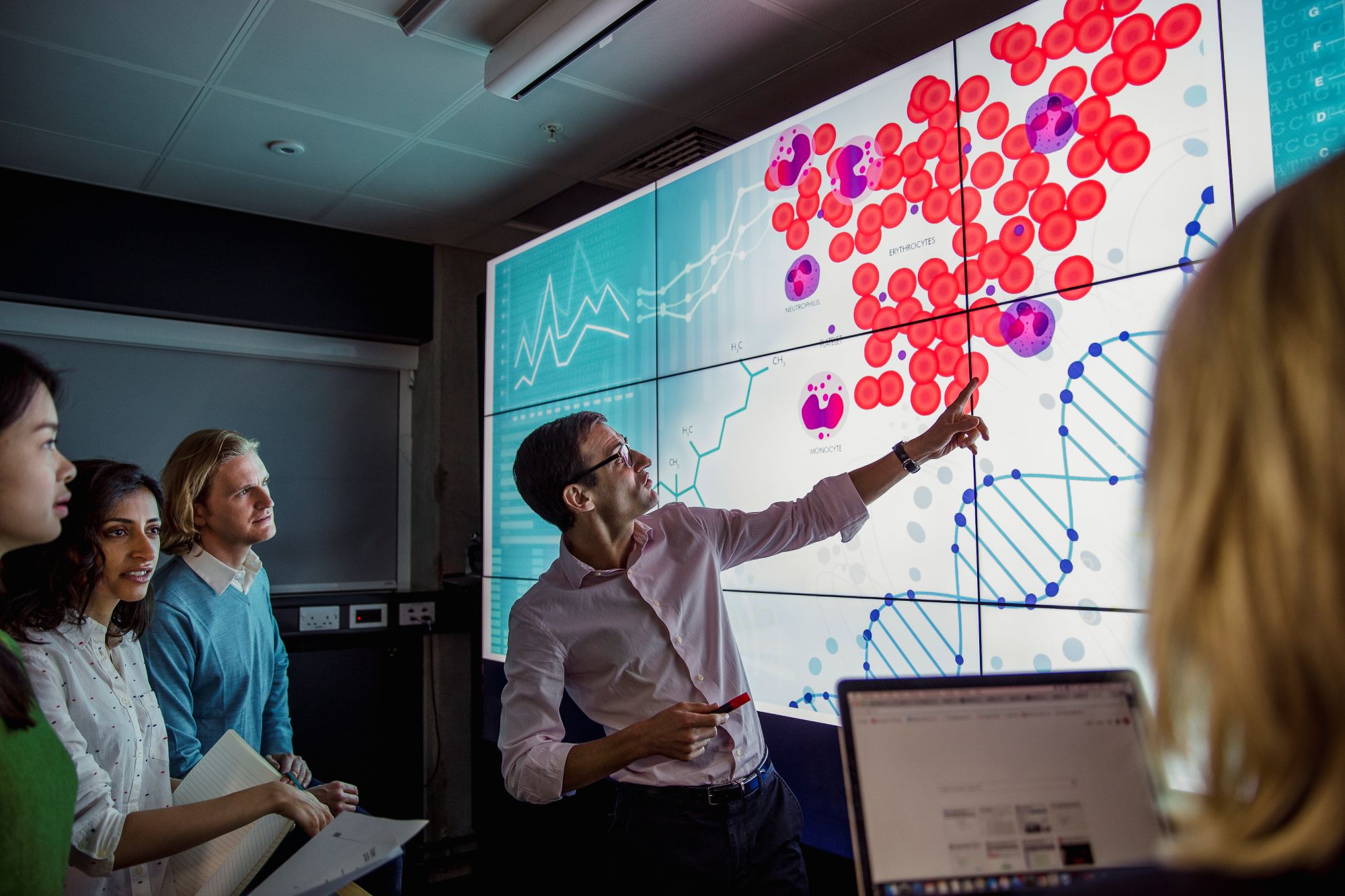 A man giving a presentation with a scientific focus to a room of people