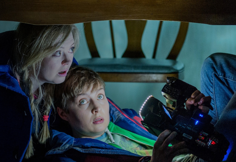 Actors on stage in theatre, with camera filming them