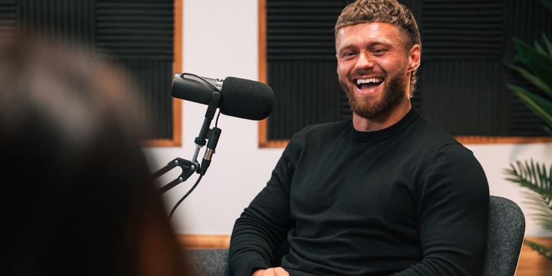Man sat in a chair, speaking to someone